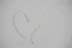 Herzen auf den Sand eines Strandes gezeichnet foto