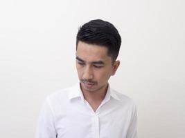 junger asiatischer Mann isoliert auf weißem Hintergrund, der seitwärts schaut foto