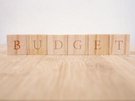 das Wort Budget, Text auf Holzwürfeln auf der Tischplatte. Hintergrund kopieren foto