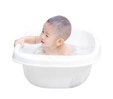 glücklicher kleiner Junge ist im weißen Bad gebadet