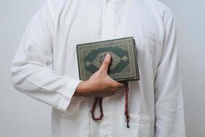 die hand des muslimischen mannes trägt den heiligen koran foto