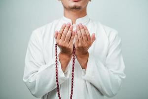 Nahaufnahme der Hand, die eine Tasbih oder Gebetskette hält foto