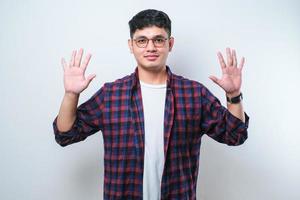 junger hübscher asiatischer mann, der lässige kleidung trägt und mit den fingern nummer zehn nach oben zeigt, während er selbstbewusst und glücklich lächelt foto