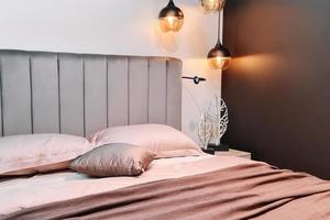 stilvolles schlafzimmerinterieur. großes bequemes Bett zum Entspannen. minimalistisches Design foto