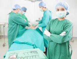 Chirurg steht vor einem Kollegen in einem Operationssaal foto