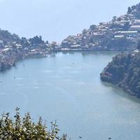 volle ansicht des naini-sees während der abendzeit nahe der einkaufsstraße in nainital, uttarakhand, indien, schöne ansicht des nainital-sees mit bergen und blauem himmel foto