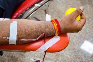 blutspender im blutspendecamp mit einem hüpfball in der hand gehalten im balaji-tempel, vivek vihar, delhi, indien, bild für den weltblutspendetag am 14. juni jedes jahr, blutspendecamp foto