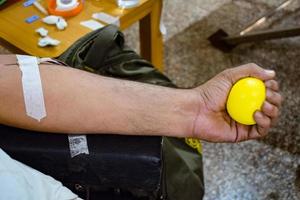 blutspender im blutspendecamp mit einem hüpfball in der hand gehalten im balaji-tempel, vivek vihar, delhi, indien, bild für den weltblutspendetag am 14. juni jedes jahr, blutspendecamp foto