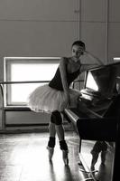 Eine bezaubernde Ballerina in einem Body posiert Ballettelemente in einem Kopfschmuck in einem Fotostudio foto