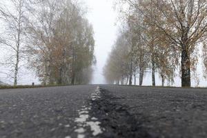 Asphaltstraße in den Nebel foto