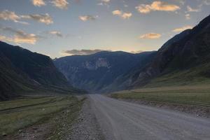 Band der Straße zwischen den Hängen der Berge auf den Weiten des Altai an einem Sommertag foto