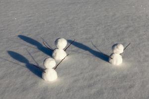 Spiele im Schnee mit dem Erstellen mehrerer Schneemannfiguren foto
