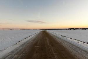 Spurrillen auf einer schneebedeckten Straße foto