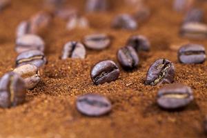 geröstete Kaffeebohnen werden auf gemahlenen Kaffee gelegt foto