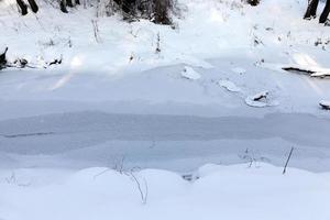 ein kleiner Fluss, dessen Wasser im Winter gefroren ist foto