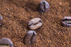 geröstete Kaffeebohnen werden auf gemahlenen Kaffee gelegt foto