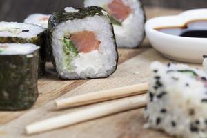 aus Reis und Forelle oder Lachs mit Avocado-Sushi-Essen foto