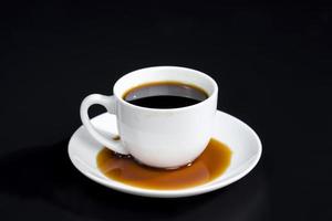 Schwarzer aromatischer Kaffee, der durch Unachtsamkeit verschüttet wurde foto