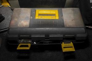 geschlossener Werkzeugkasten mit gelbem Griff und Schloss foto