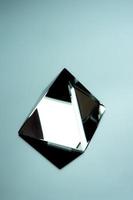 glänzende Glaspyramide auf einer Spiegelfläche. geometrisches minimalistisches Objekt. foto