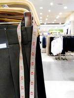 Taillenband, das an Herrenhosen mit Kopierraum und leicht verschwommenem Hintergrund im Herrenmode-Einkaufsgeschäft hängt foto