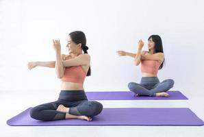 asiatische Frau, die Yoga drinnen praktiziert, mit einer einfachen und einfachen Position, um das Ein- und Ausatmen in der Dehnungsarmhaltung zu kontrollieren foto