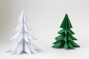 zwei Origami-grüne und weiße Weihnachtsbäume auf weißem Hintergrund. foto