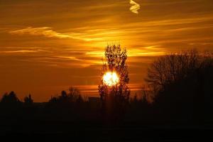 untergehende Sonne am Stadtrand von Berlin. der Himmel scheint zu brennen foto