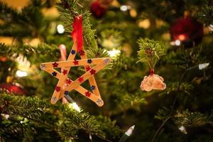 Weihnachten. Weihnachtsdekoration. Weihnachtsstern aus Holz hängt am Weihnachtsbaum foto