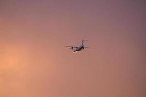 Flugzeug am Abendhimmel im leuchtenden Horizont. es geht in den urlaub foto