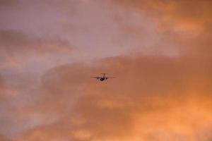 Flugzeug am Abendhimmel im leuchtenden Horizont. es geht in den urlaub foto