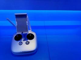 Drohnen-Joystick-Steuerung auf blauem Hintergrund und Kopierraum. Gerät, Objekt und Technik. foto