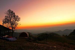 schöner sonnenunterganghimmel und baum mit bergkette im phu soi dao nationalpark, nan, thailand foto