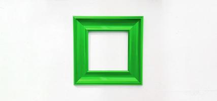 grüner leerer bilderrahmen isoliert auf weißer wand mit kopienraum. objekt auf betontapete zur dekoration zum füllen von text oder zum hinzufügen von worten. foto