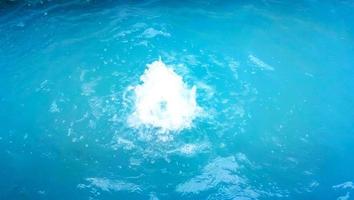 Wasseroberfläche mit Wellen und Sonnenstrahlen Reflexionen foto