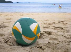 Nahaufnahme eines Beachvolleyballs auf Sand mit Meereshintergrund foto