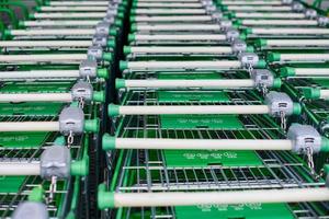 Reihe geparkter Trolleys oder Einkaufswagen im Supermarkt foto