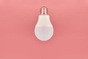 energiesparlampe, kopierraum, rosa hintergrund. minimales ideenkonzept. foto