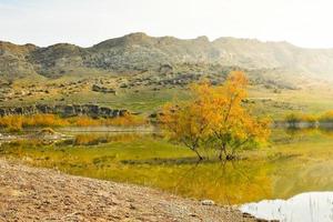 Mravaltskaro-Stausee im Herbst mit Zelt und weißen Wüstenschluchten im Hintergrund. georgia reiseziel im herbst foto