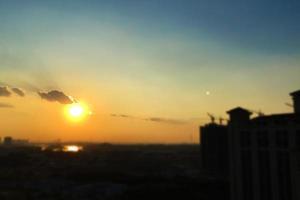 stadt- und himmelsonnenuntergang des unschärfehintergrundes. Stadtgebäude bei Sonnenuntergang. Himmel Tapete. foto