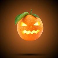 Frische Orange als Kürbiskopf, der auf pastellorangefarbenem Hintergrund fliegt. kreatives glückliches halloween-feiertagskonzept. Halloween-Party-Grußkarte. Minimales Saisonkonzept. foto