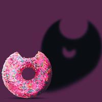 Rosa Donut mit Fledermausschatten auf violettem Hintergrund. kreatives glückliches halloween-feiertagskonzept. Halloween-Party-Grußkarte. Minimales Saisonkonzept. foto