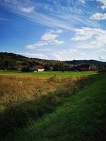 eine nahaufnahme von einem üppigen grünen feld und den dorfhäusern in ungarn foto