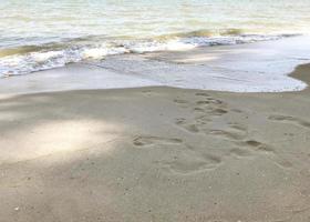 sonniger tag die meeresküste und spuren im sand foto