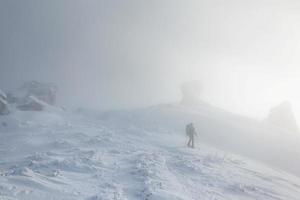 eine Frau beim Wintertrekking im Nebel foto