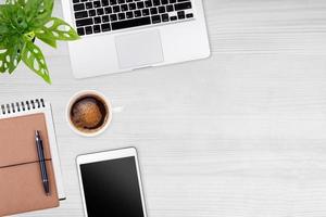 moderner arbeitsbereich mit laptop-tablet, notizbuch und kaffeetassen-kopierraum auf holztischhintergrund. Ansicht von oben. flacher Lay-Stil. foto