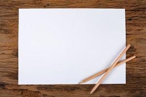 weißes Papier mit Bleistift auf Holztisch foto