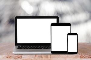 Vorderansicht des Laptops, Tablet-PC, Smartphone auf dem Arbeitstisch mit Bokeh-Hintergrund foto