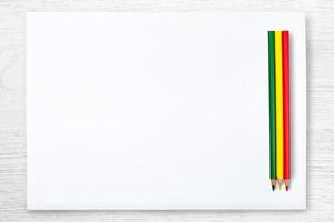 weißes papier und farbstift auf weißem holztisch, draufsicht foto