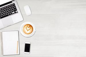 draufsicht laptop oder notebook, handy und tasse latte art kaffee auf holztisch. Geschäftsvorlagenmodell zum Hinzufügen Ihres Textes. foto